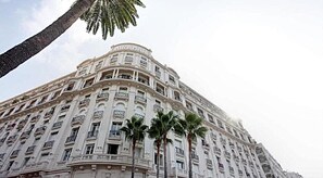 A multi-story building with a classical architectural style, featuring balconies and a curved facade. - La Croisette élégant avec balcon et vue mer aperçu (Cannes)