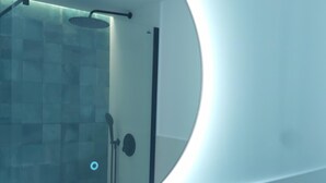 A modern bathroom with a glass shower enclosure, a towel rack, and a toilet.