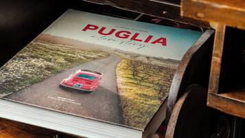 A magazine titled 'Puglia a love story' with a red car on a road.