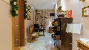 Una sala de estar con un piano de madera, un televisor, una estantería y un reloj de pared.