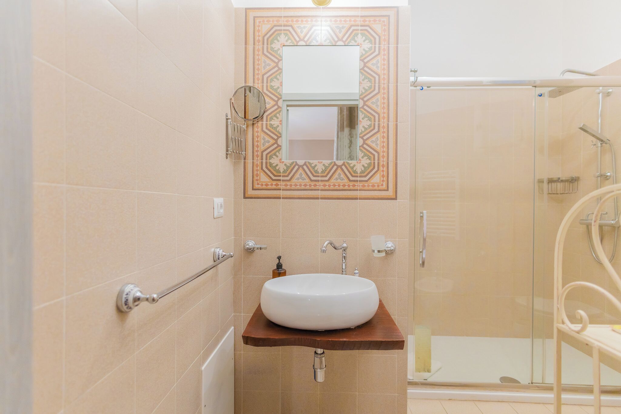 A bathroom with a white sink, a mirror, and a shower.