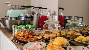 Una mesa de buffet con diferentes opciones de comida, incluyendo pizza, sándwiches y una variedad de salsas.