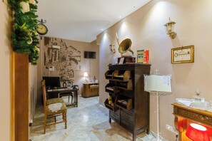 A living room with a fireplace, a clock, a television, and a bookshelf. - Bari Antica Boutique B&B (Bari)