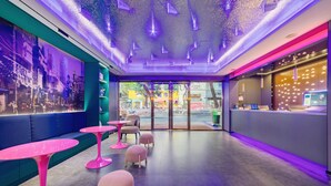 A modern interior with seating areas, a reception desk, and a view of the street outside. - Xinghe Yuezhi·S Hotel (Guangzhou Yuexiu Park Railway Station Subway Station Baima Clothing City Flagship Store) (Guangzhou)