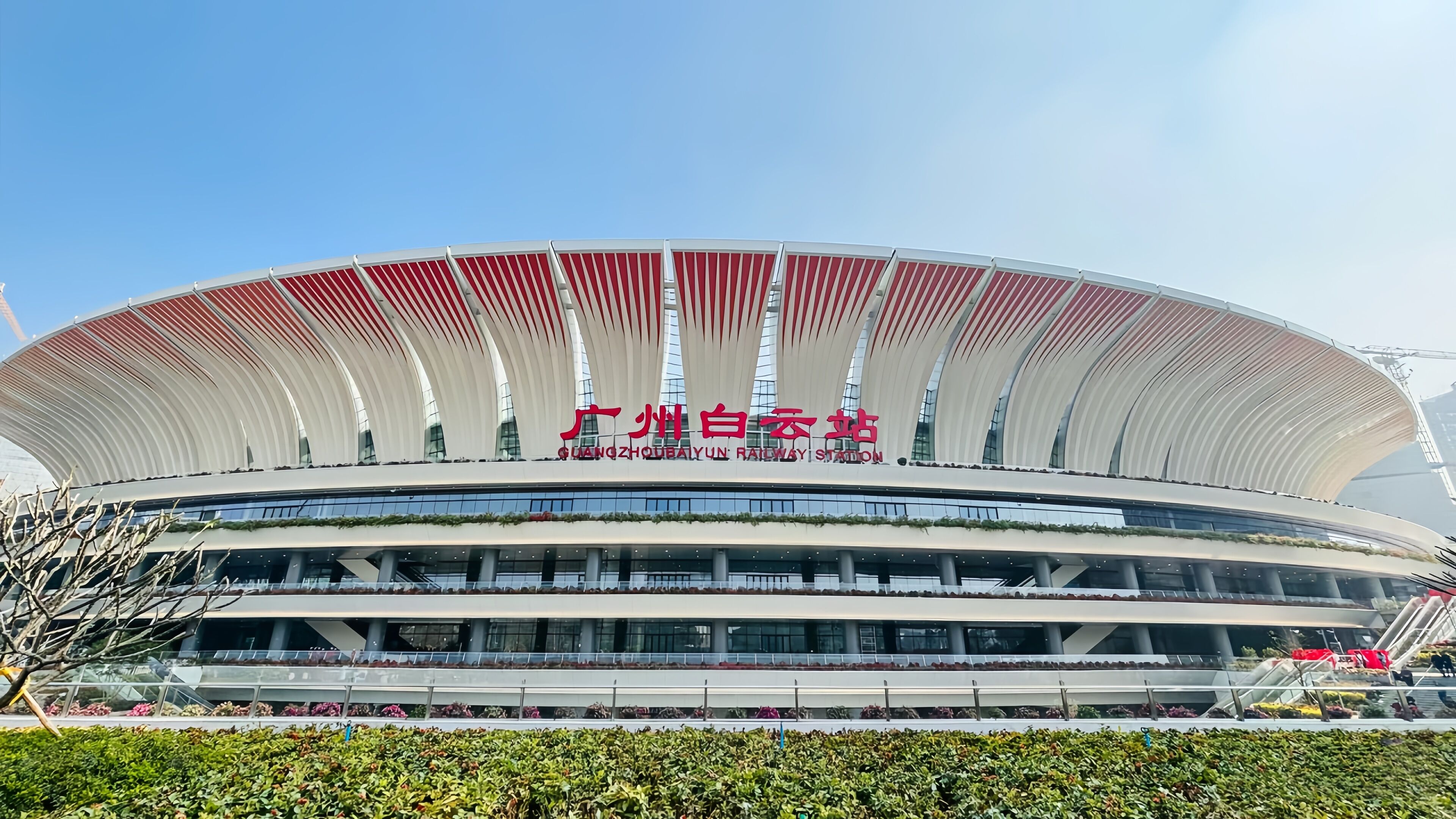 Un grand stade moderne doté d’un toit incurvé original et de plusieurs niveaux de gradins.