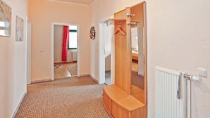 A hallway with a wooden wardrobe, a mirror, and a radiator. - Gorgeous apartment in Waren (Müritz) (Waren (Müritz))