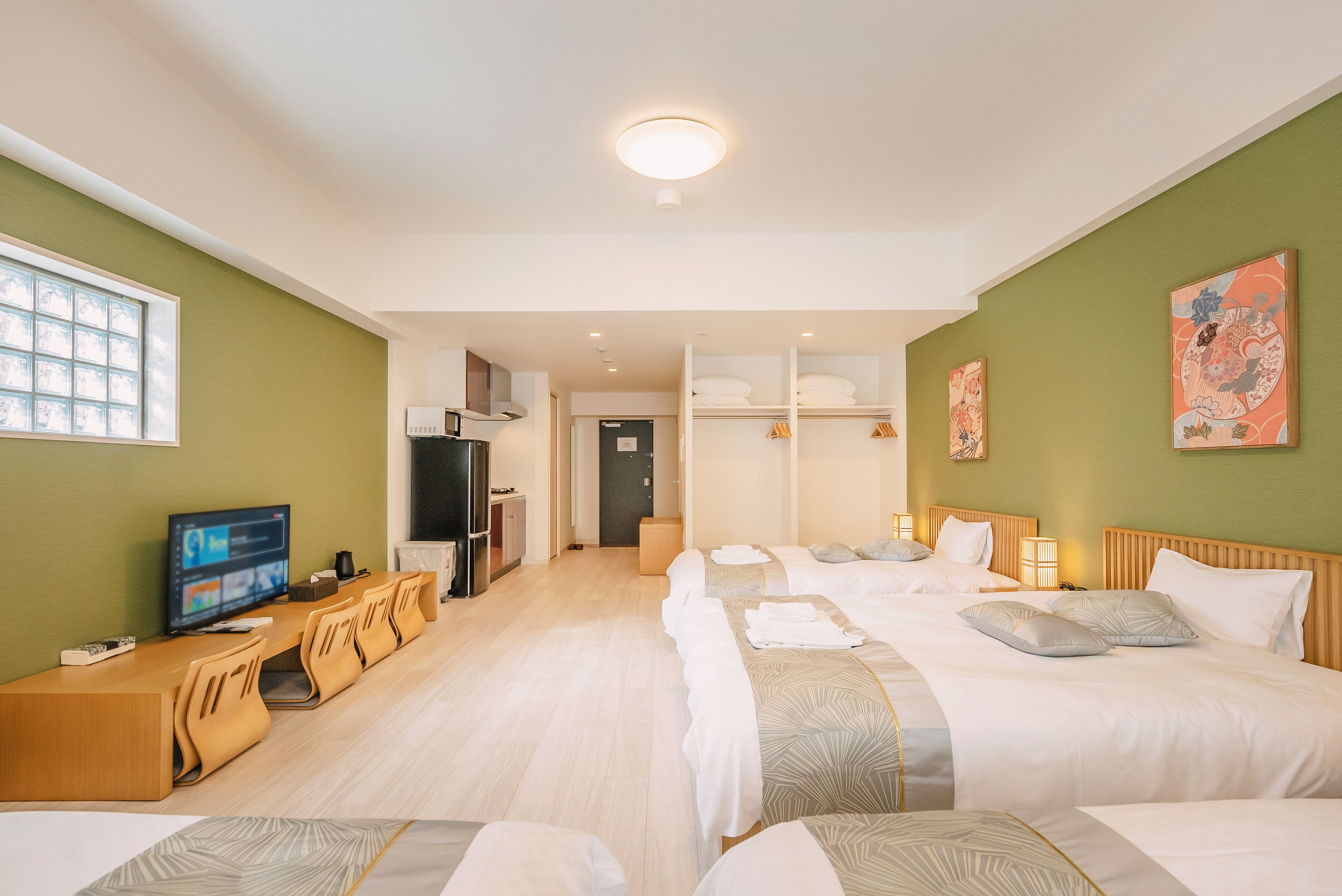 Una habitación de hotel con una cama grande, un escritorio con computadora y una ventana.