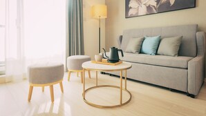 Una sala de estar moderna con un sofá gris, una mesa de centro redonda y una lámpara de pie.