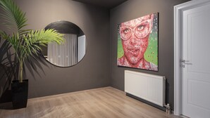 A room with a large mirror, a potted plant, a radiator, and a door. - The Riviera Hideaway (Vari-Voula-Vouliagmeni)