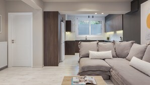 A modern kitchen with a built-in oven, a dining area with a sofa, and a view of the outdoors through a window. - The Riviera Hideaway (Vari-Voula-Vouliagmeni)