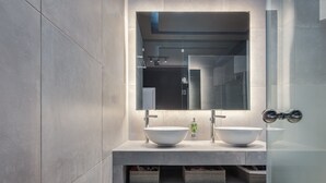 A modern bathroom with two large white bowls on a countertop, a mirror above, and storage baskets below. - The Riviera Hideaway (Vari-Voula-Vouliagmeni)