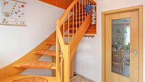 Eine Holztreppe mit Glastür am unteren Ende.