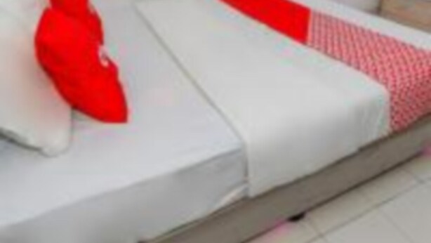A single bed with white bedding and a red accent pillow. - OYO 93811 As Property (Depok)