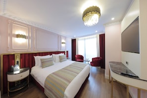 A hotel room with a large bed, a desk, a TV, and a chandelier. - Golden Horn Bosphorus Hotel (Istanbul)