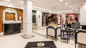 A hotel lobby with a reception desk, a chandelier, a seating area, and a decorative wall. - Golden Horn Bosphorus Hotel  (Istanbul)