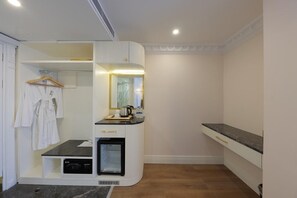 Uma casa de banho moderna com chuveiro integrado, toucador com espelho e porta-toalhas.