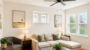A living room with a sofa, armchair, coffee table, and two lamps. - Central Dog-Friendly Apartment | Office (Saint Louis)