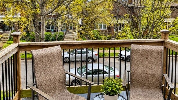 A balcony with wicker chairs, a small round table, and a potted plant. - Central Dog-Friendly Apartment | Office (Saint Louis)
