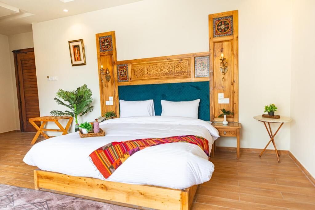 A bedroom with a wooden bed, a blue upholstered headboard, and decorative wall panels.