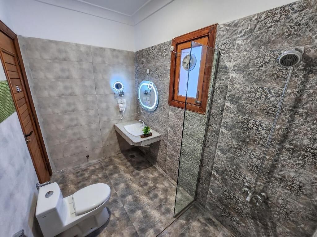Een badkamer met toilet, wastafel en douche.