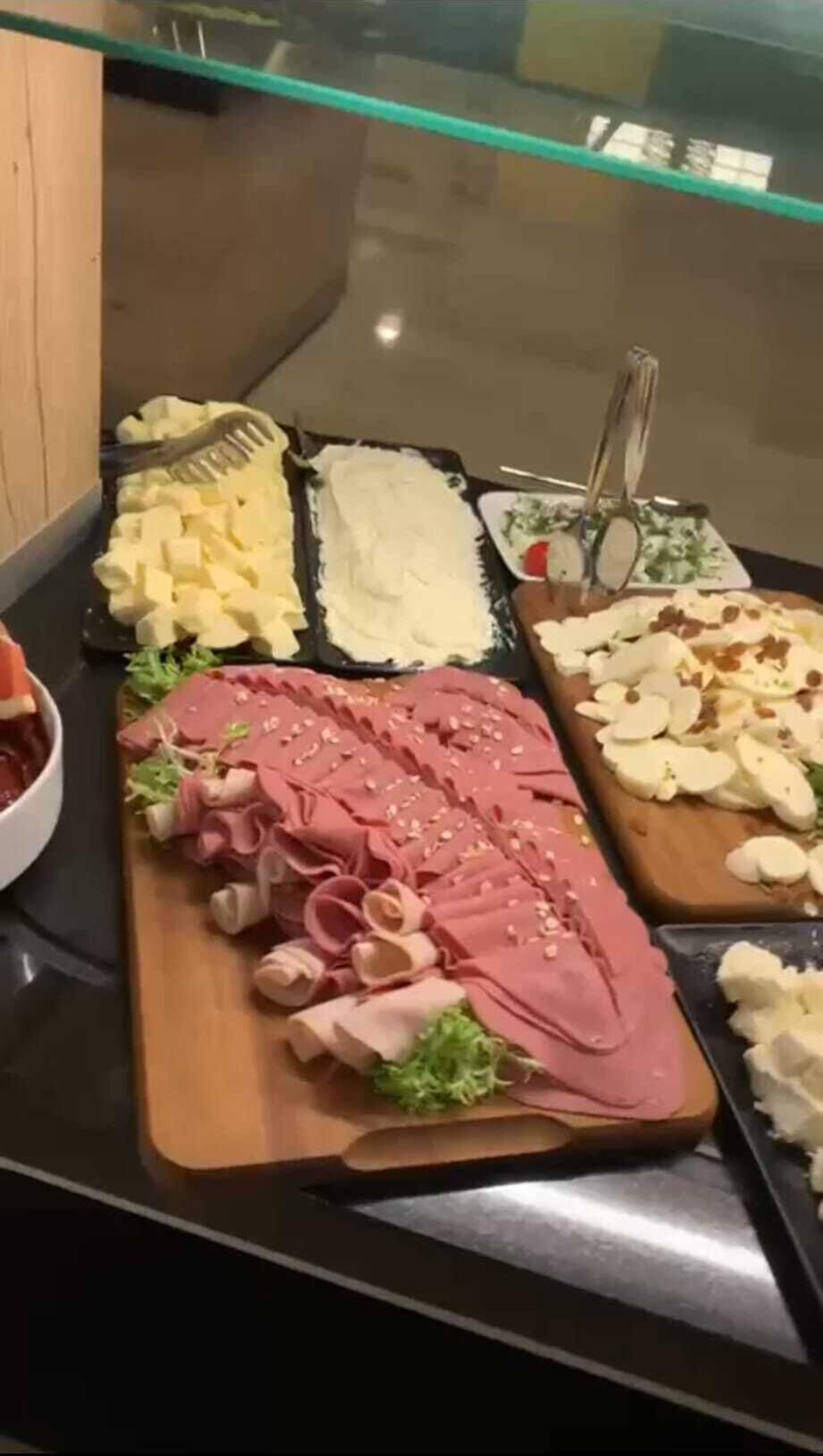 Ein reichhaltiges Buffet mit verschiedenen Speisen, darunter Fleisch, Käse und Obst.