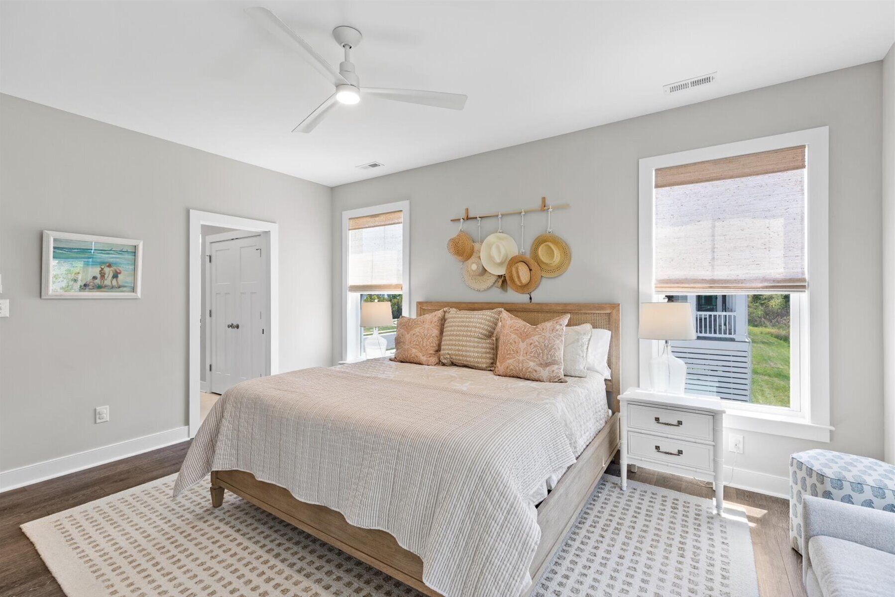 Main level primary suite with king bed, access to covered porch, bathroom with walk-in shower and double sinks