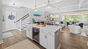 A spacious kitchen with white cabinetry, a central island, and pendant lighting. - 5BR Beauty Near Bethany-Community Pool; Linens (Ocean View)