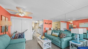 A living room with teal sofas, a white coffee table, and a ceiling fan. - Private Pool Steps From the Beach (Ocean City)
