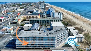 A coastal hotel with a parking lot, a pool area, and a view of the beach. - Private Pool Steps From the Beach (Ocean City)