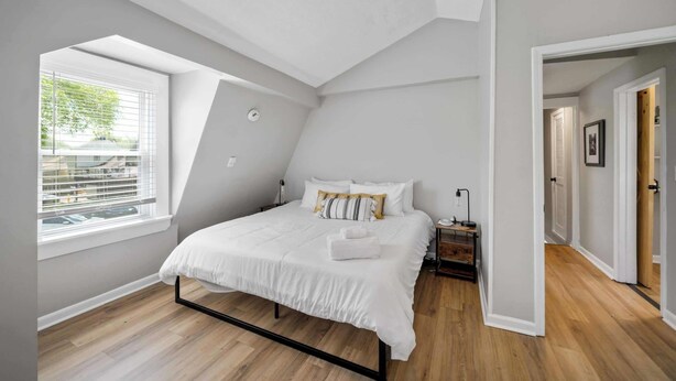 A bedroom with a bed, a ceiling fan, a window, and a nightstand. - Relaxing historic home close to Churchill Downs! (Louisville)
