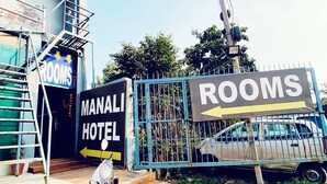 A hotel entrance with a sign indicating 'MANAGEMENT HOTEL' and 'ROOMS' with a directional arrow. A scooter is parked in front. - Manali Hotel By GRB (New Delhi)