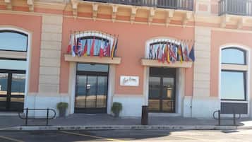 Fachada de hotel con dos entradas arqueadas, un cartel que dice "Hotel Europa" y varias banderas nacionales a la vista.