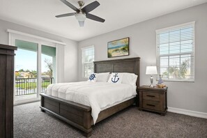 A bedroom with a bed, a nightstand, a ceiling fan, and a window with blinds. - 5BR family townhome near the beach w/ pool (Indian Harbour Beach)