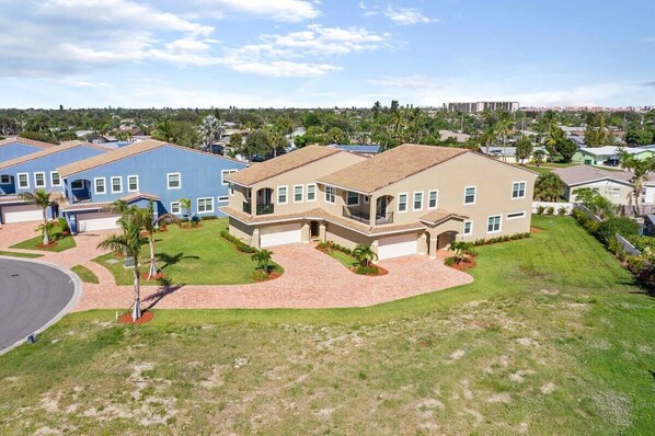 A residential building with a tiled roof, a driveway, and a well-maintained lawn. - 5BR family townhome near the beach w/ pool (Indian Harbour Beach)