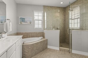 Une salle de bain avec une baignoire, une douche et un grand miroir.
