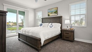 A bedroom with a bed, a nightstand, a ceiling fan, and a window with blinds. - Fortebello Beachside 156 (Indian Harbour Beach)