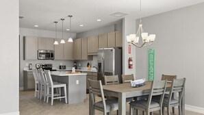 A modern kitchen with a central island, stainless steel appliances, and pendant lighting. - Private Pool! Fortebello Beachside 162 (Indian Harbour Beach)