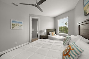 A bedroom with two beds, a ceiling fan, a window with blinds, and a door leading to another room.