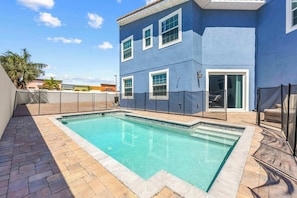 Un edificio residencial con piscina, un patio cubierto y vistas del entorno.