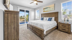 A bedroom with a bed, a wooden nightstand, a ceiling fan, a TV, and a window with blinds. - Fortebello Beachside 170 With PRIVATE POOL (Indian Harbour Beach)