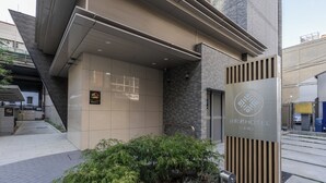 A hotel entrance with a modern design, a reception desk, and a signboard. - Tanimachikun Hotel Niponbashi47 (Osaka)