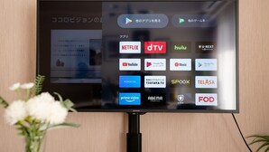 A flat-screen TV mounted on a wall displaying various streaming service icons. - Tanimachikun Hotel Niponbashi47 (Osaka)