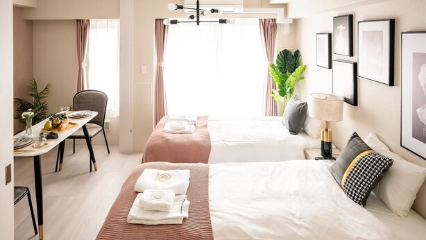 A hotel room with two beds, a dining area, and a view of the city. - Tanimachikun Hotel Niponbashi47 (Osaka)