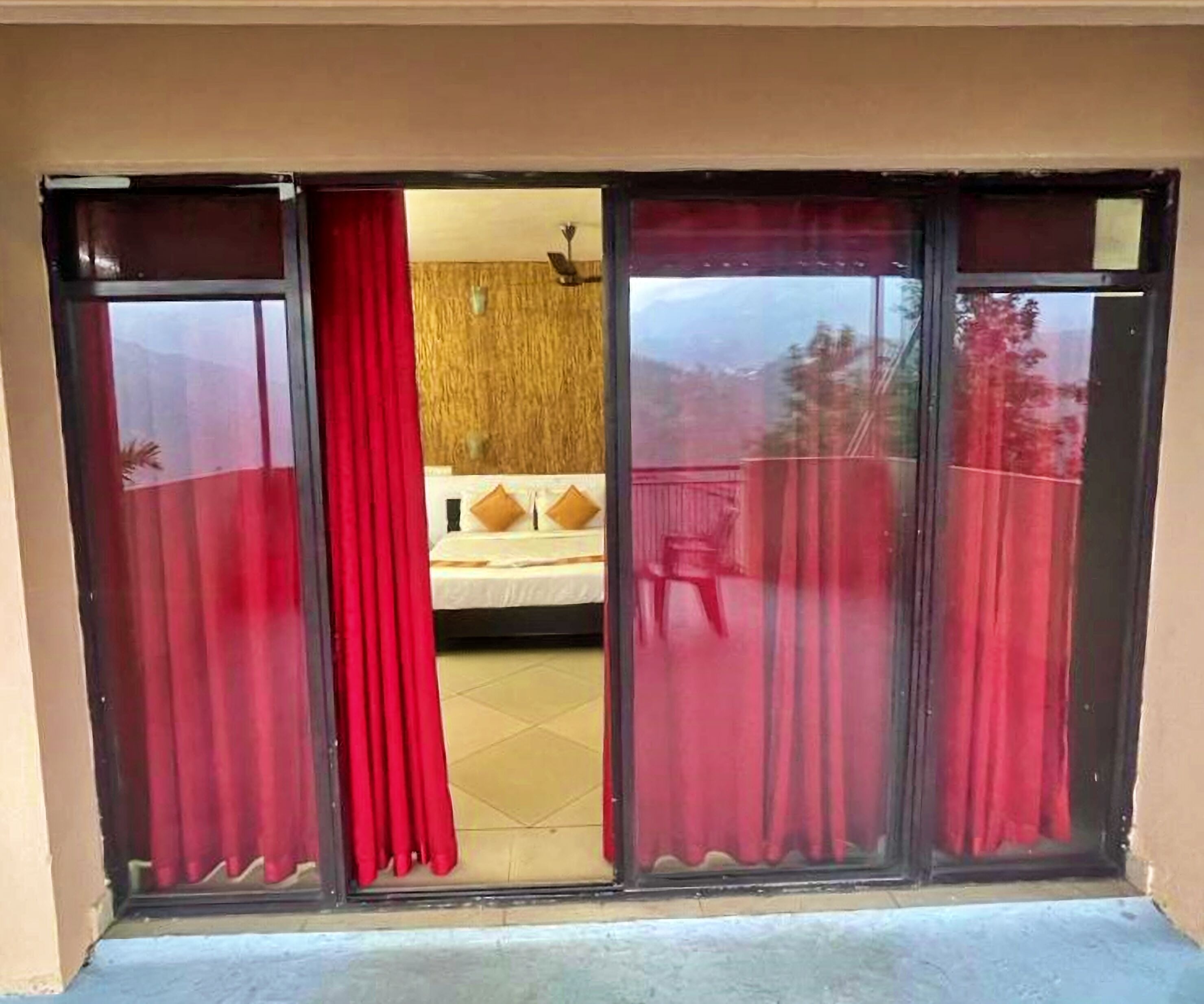 Una habitación con una cama, una pared de madera y vistas al exterior.