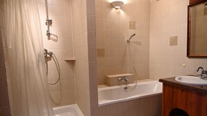 Une salle de bain avec une baignoire, une douche et un lavabo.