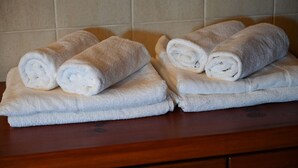 Deux piles de serviettes blanches sur un comptoir en bois.
