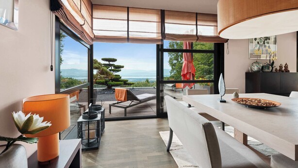 Un interior moderno con comedor, vistas al exterior y techo de madera.
