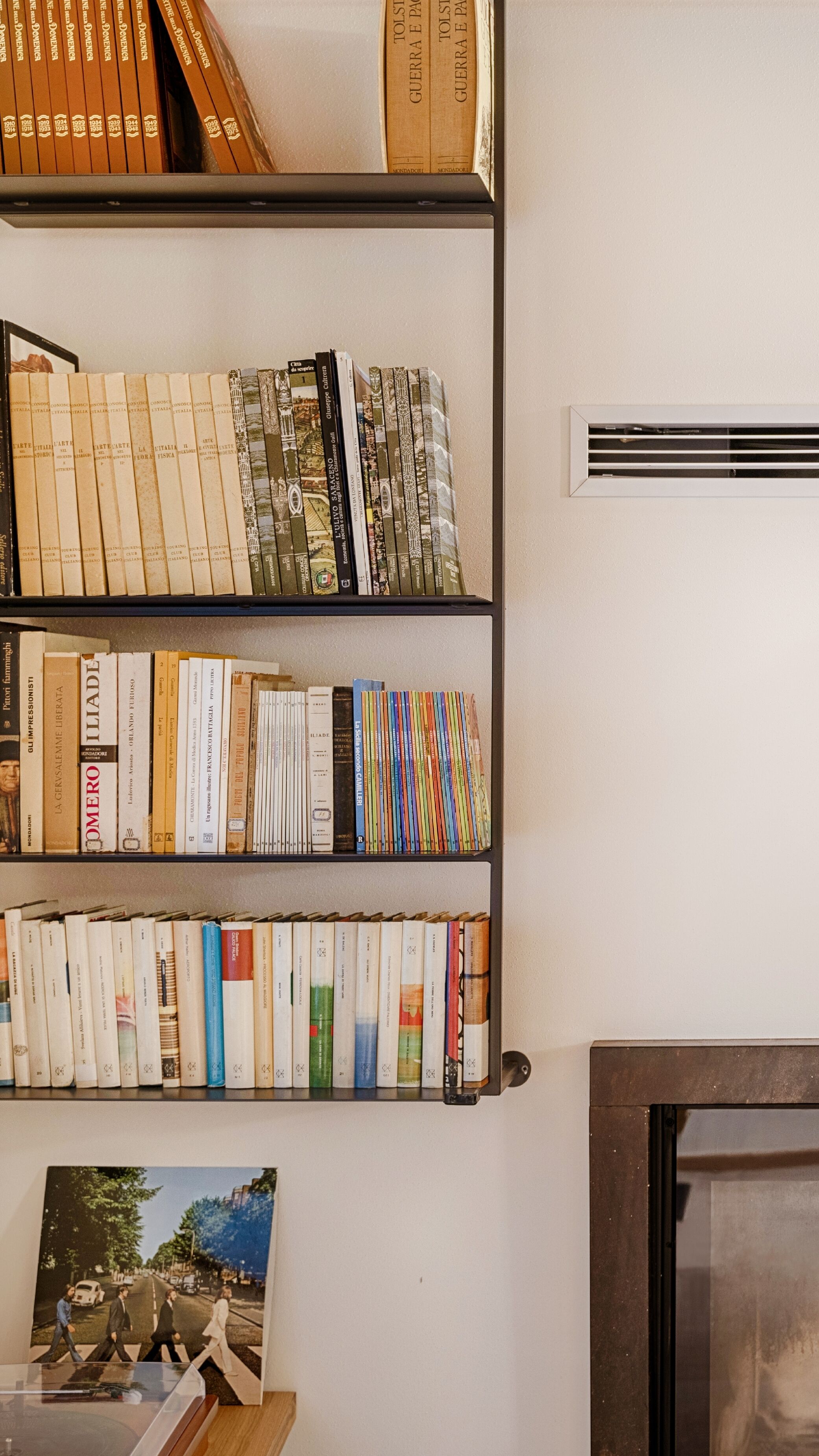 A bookshelf with various books and a Beatles album cover.
