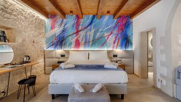 Un dormitorio moderno con una cama grande, un escritorio y una pared de piedra.
