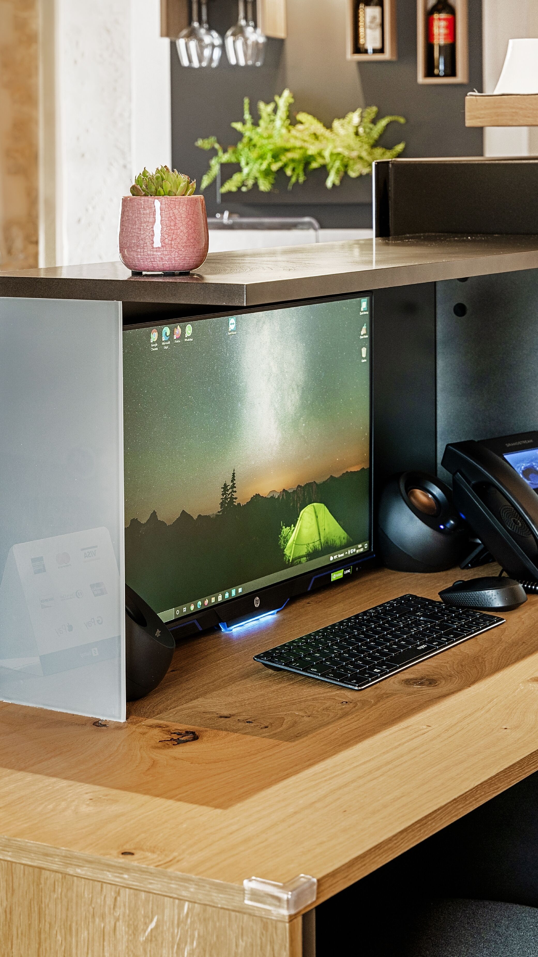 A wooden desk with a desktop computer, keyboard, and mouse.